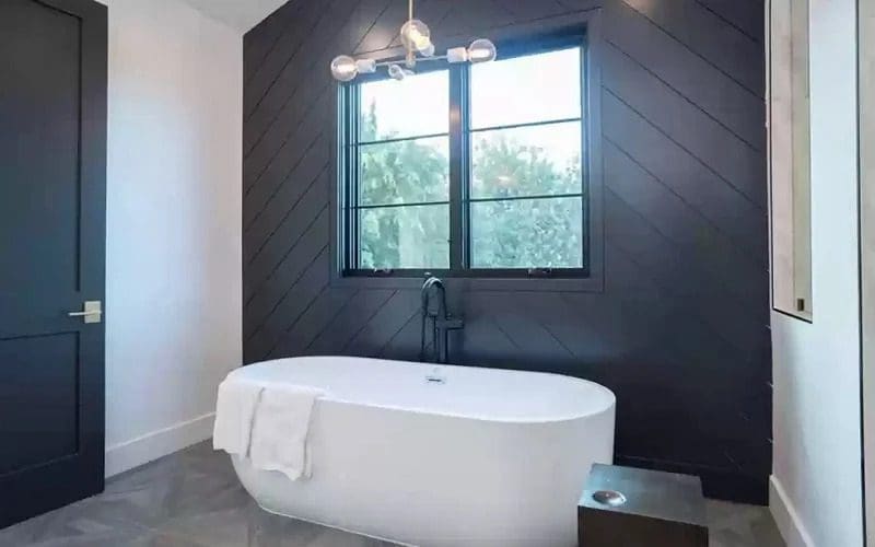 Bathtub with a nice lighting fixture above it