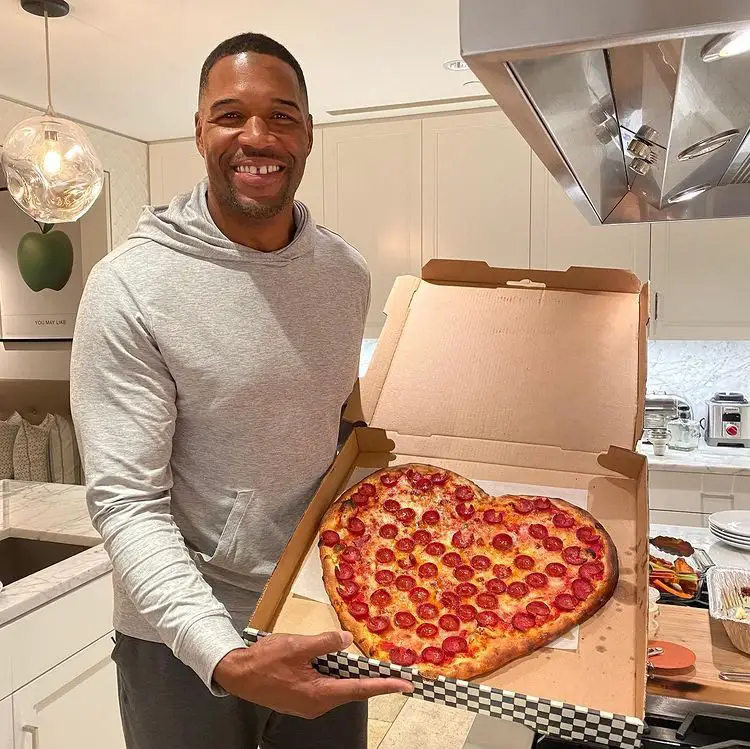 Michael Strahan holding a pizza box