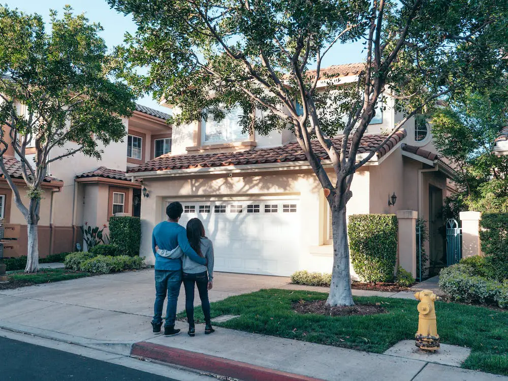 Free Couple Standing In Front of their House Stock Photo