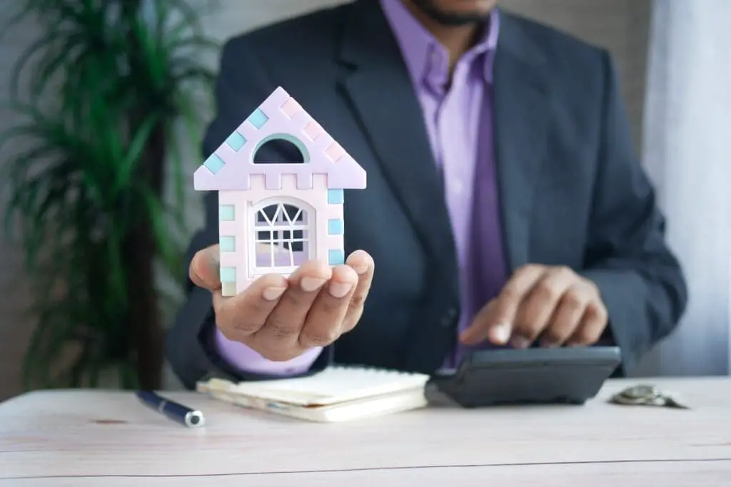 Mortgage Broker Holding A Toy House